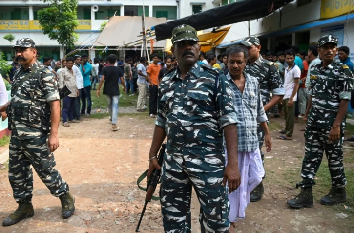 Des militaires indiens montent la garde devant un bureau de vote lors d'un scrutin local au Bengale-occidental, le 8 juillet 2023 dans la banlieue de Calcutta
