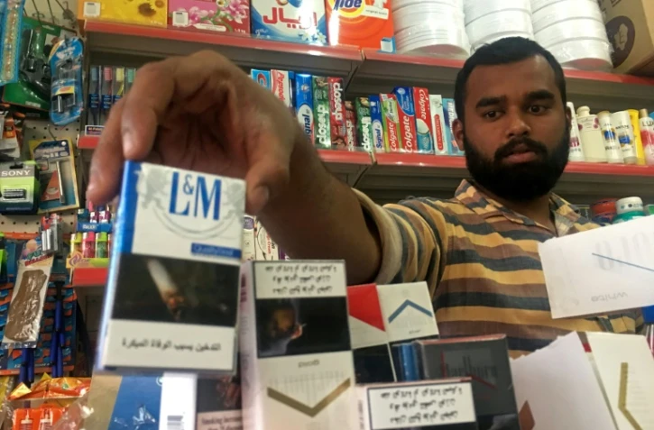 Un homme range des paquets de cigarettes à Ras al-Khaimah le 28 septembre 2017