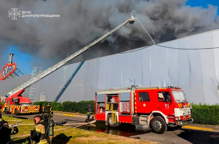 Photo diffusée par le Service d'État ukrainien pour les situations d'urgence, le 21 août 2026, montrant des pompiers luttant contre un incendie sur le site d'un centre commercial endommagé par une frappe russe à Kryvyï Rih, en Ukraine