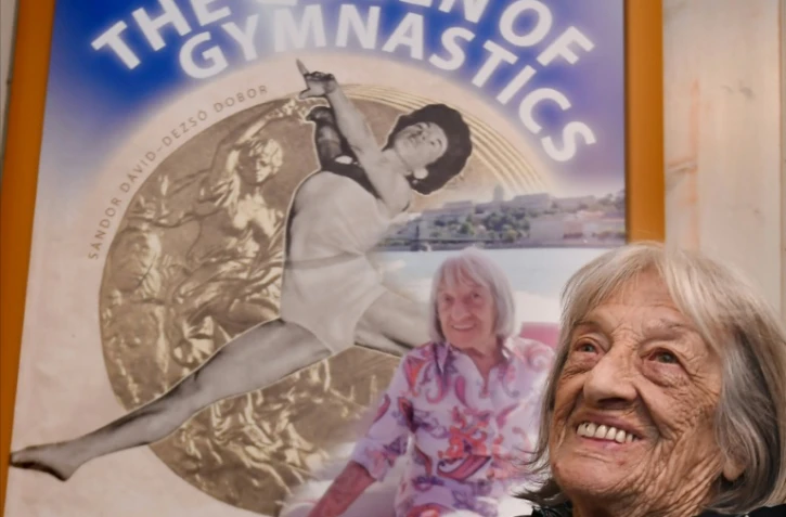 La championne olympique hongroise Agnes Keleti devant une affiche de sa biographie, parue pour son centième anniversaire, le 6 novembre 2020 à Budapest