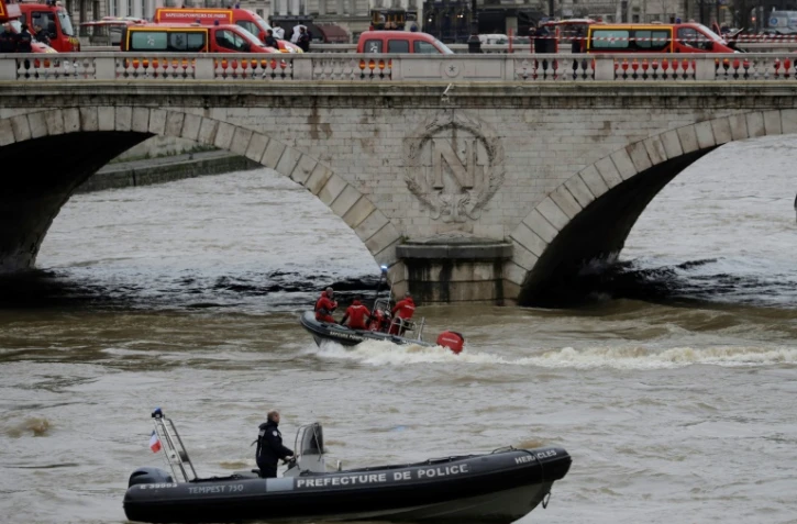 Pompiers et policiers tentent de retrouver une policière de la brigade fluviale disparue lors d'un exercice dans la Seine, le 5 janvier 2018