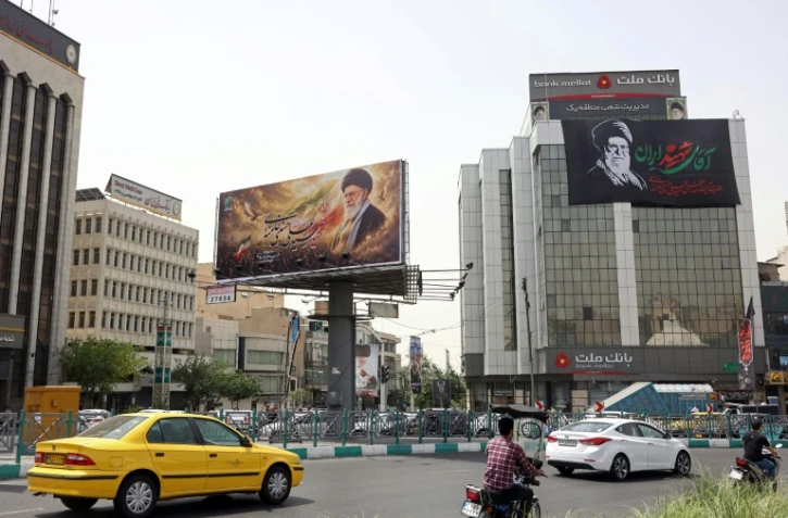 Des automobilistes passent devant d'immenses panneaux publicitaires arborant des photos de l'ayatollah Ali Khamenei, le défunt guide suprême de l'Iran, le 2 juillet 2026 à Téhéran, à la veille de ses funérailles