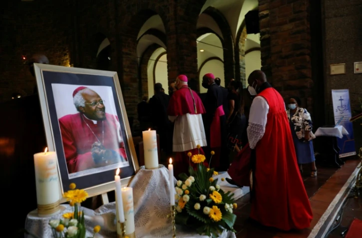 Des religieux passent devant un portrait de Desmond Tutu à la cathédrale Saint-Georges, au Cap le 30 décembre 2021