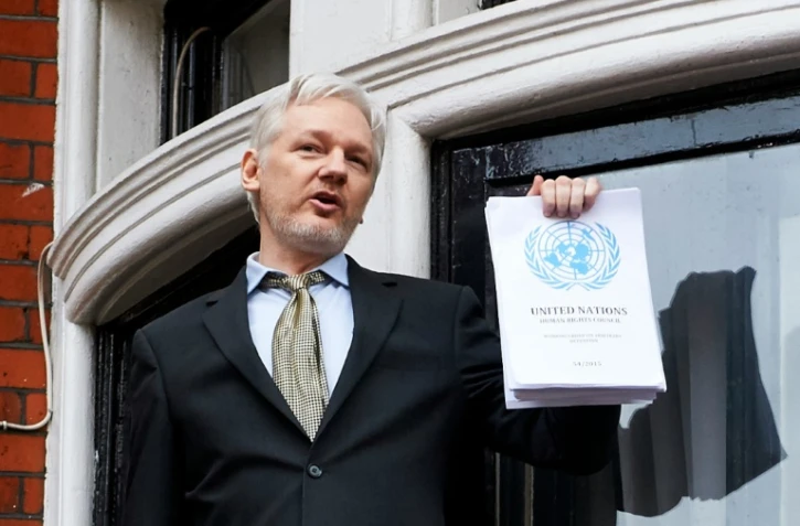 Julian Assange, tenant à la main un rapport d'un groupe de travail de l'ONU en sa faveur, le 5 février 2016 à l'ambassade d'Equateur à Londres