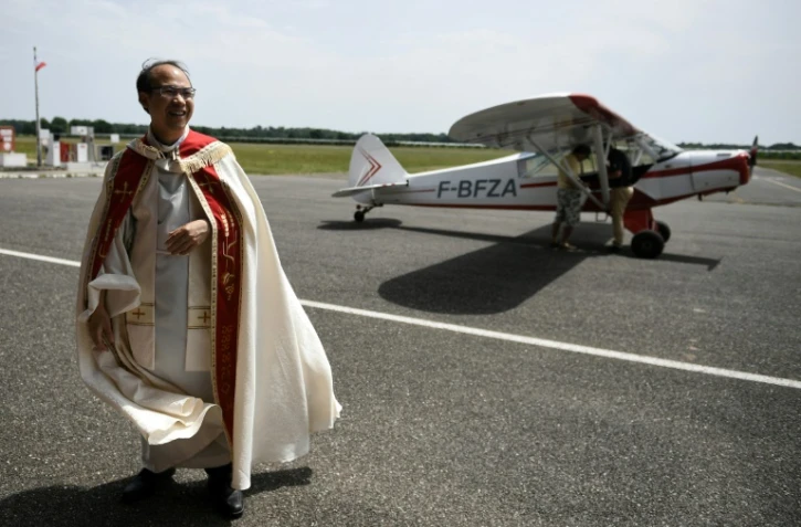 Le curé de Moissac en aube blanche, Pierre Hoan, à l'aérodrome Gandalou, le 21 mai 2022 à Castelsarrasin, dans le Tarn-et-Garonne