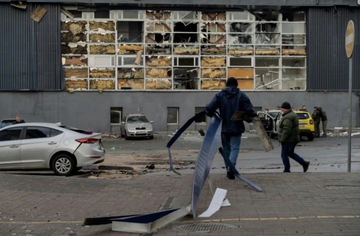 Des habitants dégagent des débris après une frappe à Kiev, le 18 janvier 2025