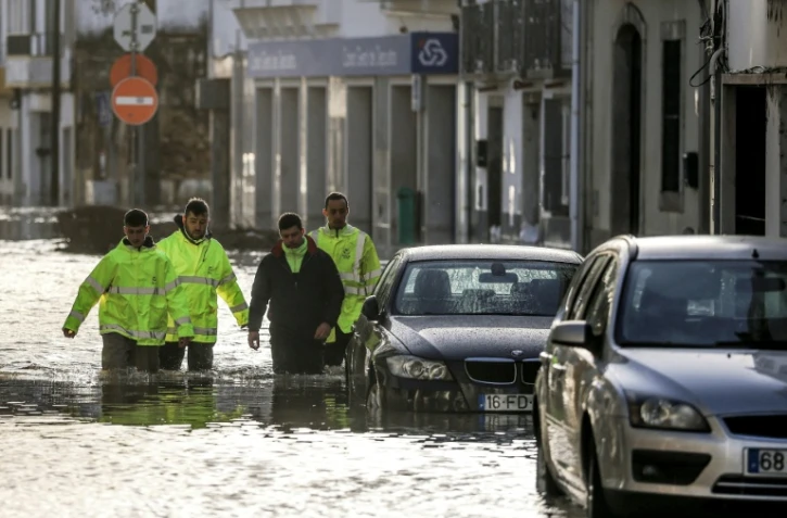 Des employés municipaux dans une rue inondée à Alcacer do Sal, dans le sud du Portugal, le 5 février 2026