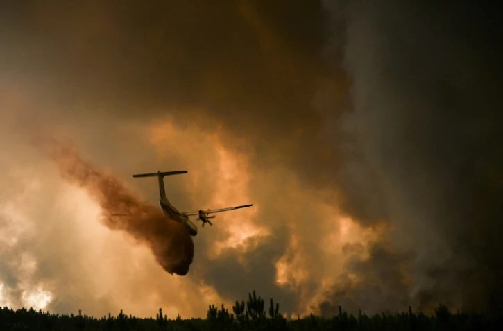 Un avion pulvérise du retardateur de feu sur les arbres lors d'un incendie de forêt près de Belin-Beliet en Gironde, dans le sud-ouest de la France, le 10 août 2022