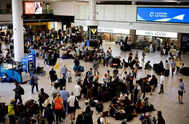 Des voyageurs attendent à l'aéroport de Gatwick alors que des vols sont annulés ou retardés en raison d'une panne informatique mondiale, le 19 juillet 2024 au Royaume-Uni
