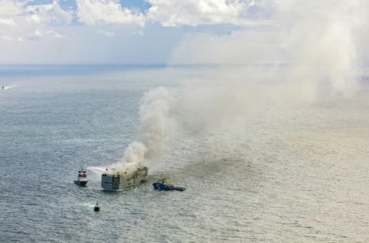 Vue aérienne des navires de secours luttant contre un feu à bord du cargo Fremantle Highway au large de l'île d'Ameland, le 26 juillet 2023 aux Pays-Bas
