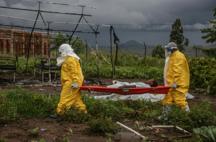 Du personnel médical transporte un patient sur un brancard à l'hôpital de Rwampara, le 21 mai 2026, en OUganda, tout près de la République Démocratique du Congo, touchée par une épidémie d'Ebola