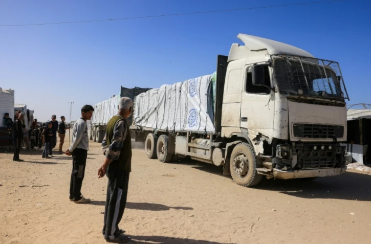 Des Palestiniens observent l'arrivée de camions transportant de l'aide humanitaire à Khan Younès, dans le sud de la bande de Gaza, après leur entrée par le côté égyptien du passage frontalier de Rafah, le 1er février 2026