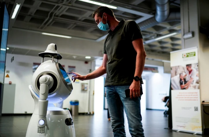 Un employé de la compagnie ZoraBots teste un robot appelé CRUZR le 29 mai 2020 à l'hôpital d'Anvers