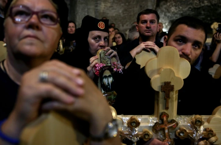Des chrétiens orthodoxes serbes portent des croix de bois dans l'église Saint-Sépulcre à Jérusalem, le 29 avril 2016