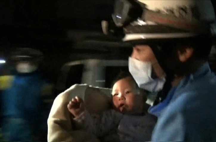 Capture d'écran d'une vidéo fournie par la préfecture de police de Kunamoto le 15 avril 2016 montrant un sauveteur sortant des décombres un bébé de huit mois, après un séisme qui a fait neuf morts au Japon