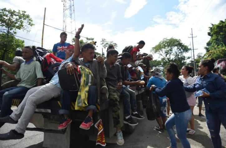 Des Guatémaltèques offrent de la nourriture et des boissons à des migrants partis du Honduras et qui comptent rallier les Etats-Unis. Photographie prise le 17 octobre 2018 à Teculutan, au Guatemala