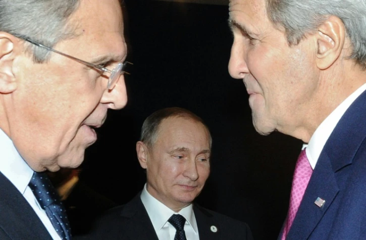 Le ministre russe des Affaires étrangères, Sergueï Lavrov (g) et son homologue américain John Kerry (d) discutent devant le président russe Vladimir Poutine (c), à Paris le 30 novembre 2015