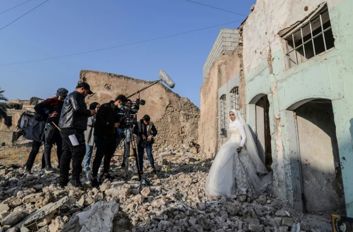 Des étudiants en cinéma tournent un court-métrage dans les ruines de la ville irakienne de Mossoul, ancien fief de l'Etat islamique, le 15 décembre 2021