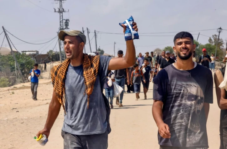 Un Palestinien montre un paquet reçu à un point de distribution d'aide humanitaire dans la région de  Rafah, dans le sud de la bande de Gaza, le 28 juillet 2025