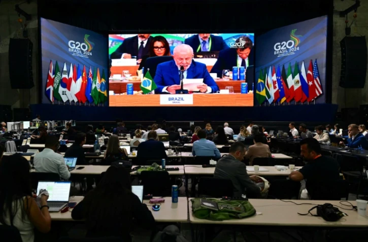 Des journalistes regardent sur un écran le président brésilien Luiz Inacio Lula da Silva pendant le G20 à Rio de Janeiro, le 19 novembre 2024