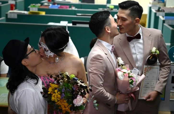 Les premiers couples homosexuels officiellement mariés s'embrassent, à Taipei, le 24 mai 2019