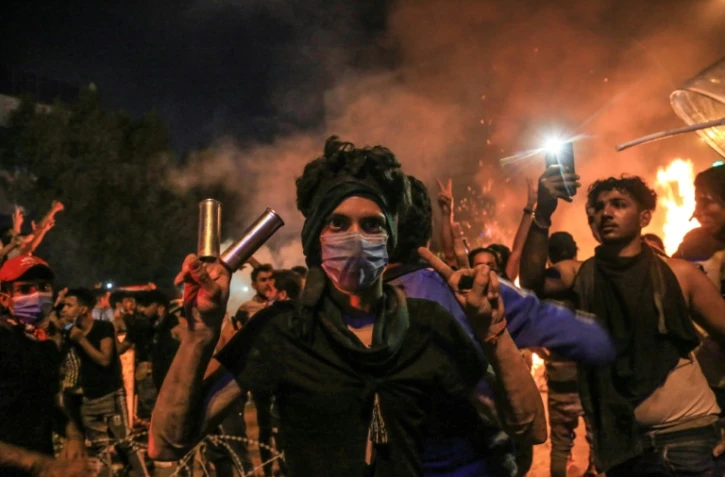 Un Irakien portant un masque à gaz et faisant le V de la victoire au cours d'une manifestation anti-gouvernementale à Kerbala, une ville chiite au sud de Bagdad le 28 octobre 2019