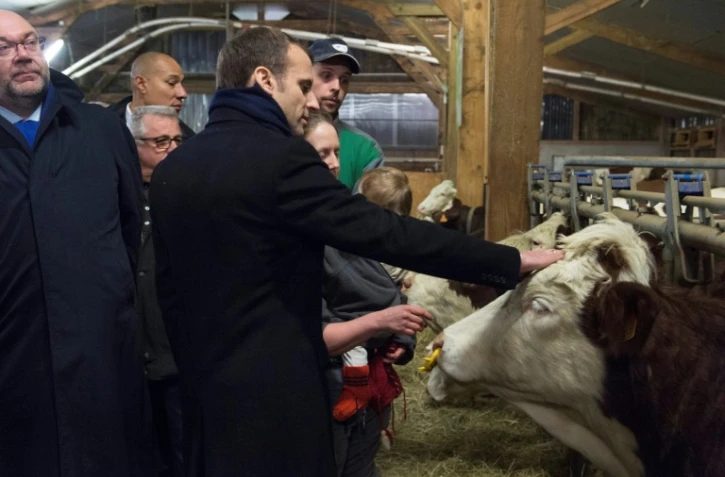 Le Président français Emmanuel Macron (C) et le ministre de l'Agriculture Stephane Travert (G) visitent une ferme à  Aurieres, le 25 janvier 2018