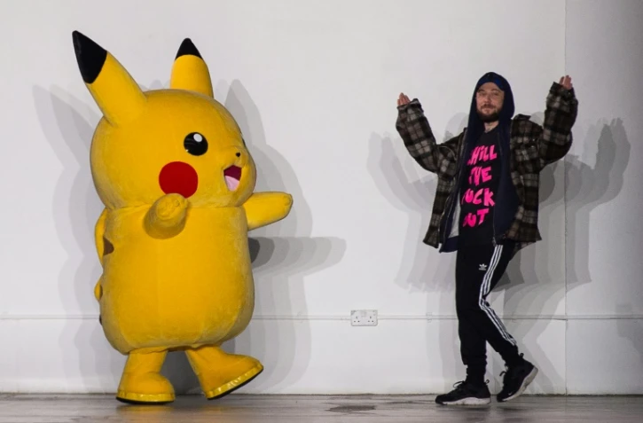 Le designer britannique Bobby Abley vient saluer avec un Pikachu géant à la fin de son défilé automne/hiver 2019 lors de la Fashion week hommes à Londres, le 5 janvier 2019