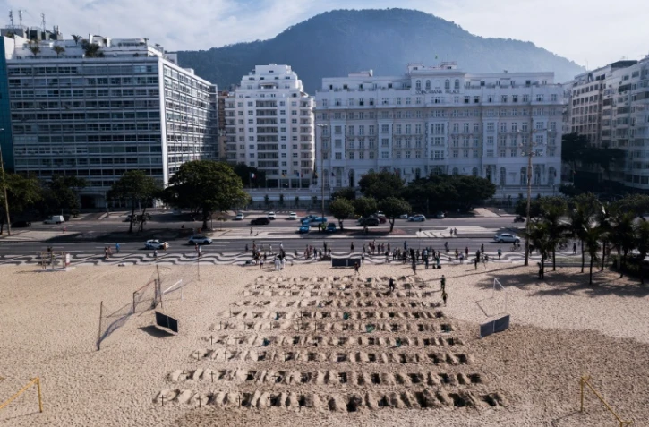 Vue aérienne des tombes symboliques creusées sur la célèbre plage de Copacabana par l'ONG Rio de Paz, à Rio de Janeiro, le 11 juin 2020
