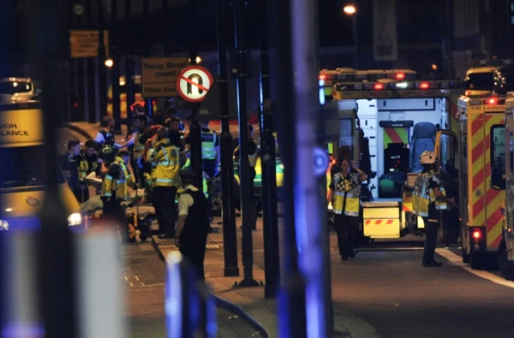Des officiers de police et les services de secours sur le London Bridge, à Londres, le 3 juin 2017, où une camionnette a foncé sur la foule, un acte qualifié par la police de "terroriste"