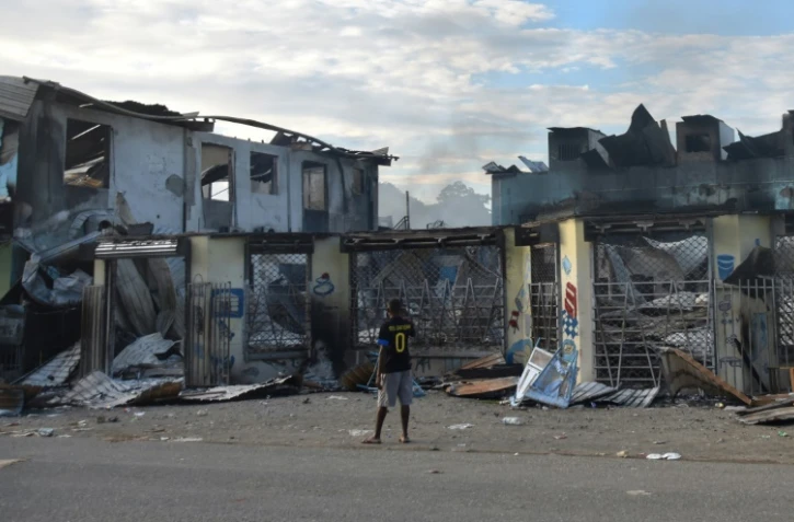 Un homme regarde les dégâts à Honiara le 27 novembre 2021