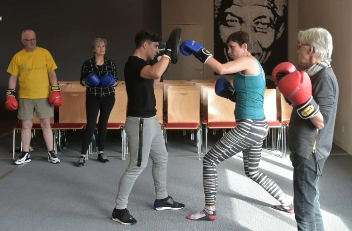 Des patients s'entraînent à la boxe avec le coach Thibault Kuhn (c), au centre de lutte contre le cancer Paul-Strauss à Strasbourg, le 6 octobre 2016