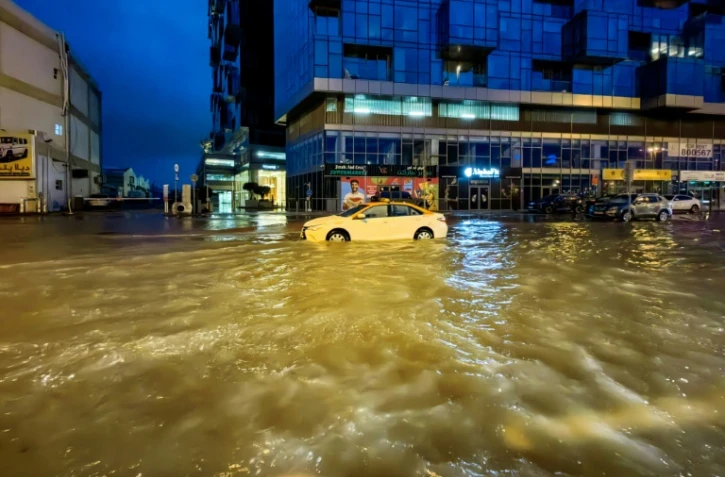 Un taxi traverse une rue inondée après des fortes pluies à Dubaï, le 17 avril 2024