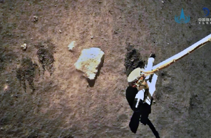 Image, diffusée le 2 décembre 2020 par l'Agence spatiale chinoise via CNS, de la sonde Chang'e 5 prélevant des échantillons du sol lunaire