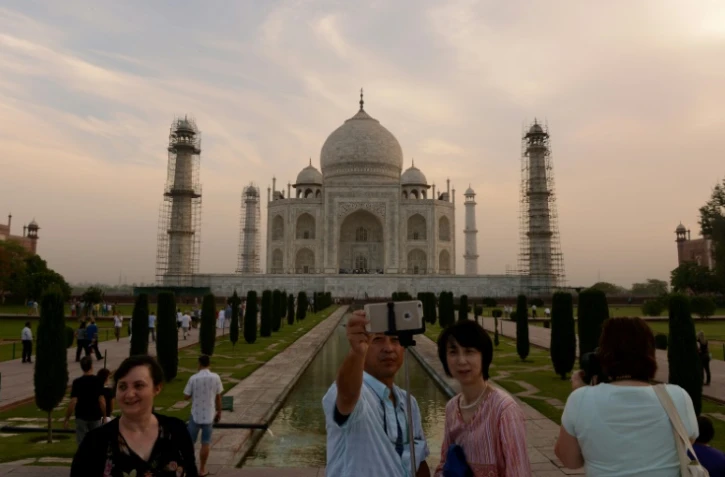 Des touristes prennent un selfie devant le Taj Mahal à Agra, le 16 avril 2016