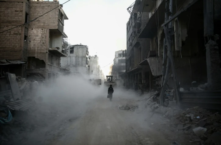 Un enfant marche à travers les décombres d'une rue de Douma, près de Damas, le 22 novembre 