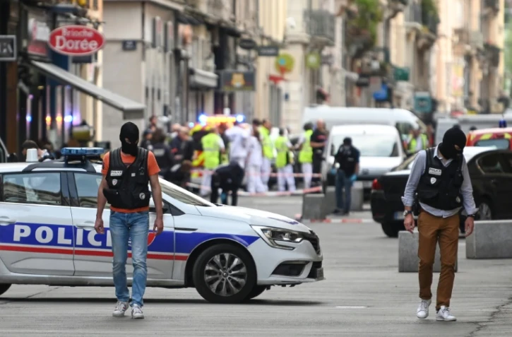 Des policiers sécurisent un périmètre devant "La Brioche dorée" après l'explosion d'un colis piégé dans une rue piétonne de Lyon, le 24 mai 2019