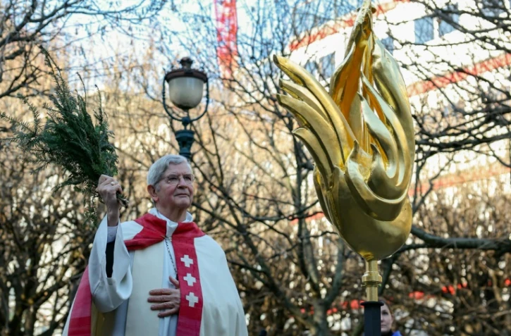 L'archevêque de Paris Laurent Ulrich bénit le nouveau coq avant son installation au sommet de la flèche de la cathédrale Notre-Dame, à Paris le 16 décembre 2023