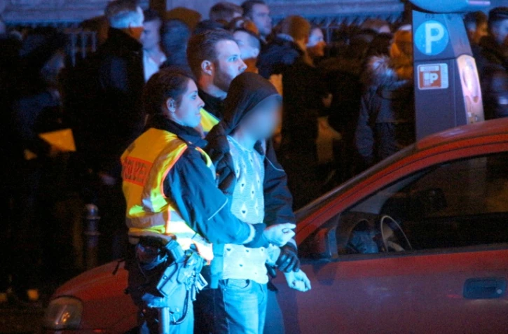 La police arrête un homme parmi ceux rassemblés devant la gare centrale de Cologne, la nuit de la Saint Sylvestre