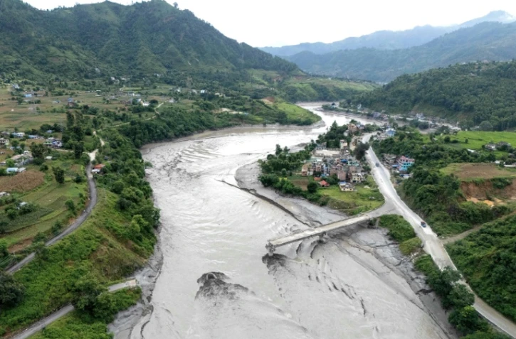 Un pont en partie détruit au-dessus de la rivière Trishuli après la crue destructrice dans l'Himalaya, le 30 août 2026 dans le district népalais de Dhading