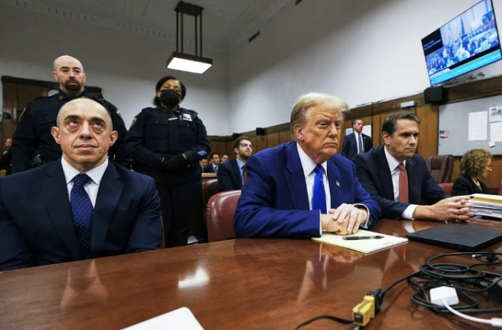 L'ancien président américain Donald Trump (c) assiste à son procès au tribunal pénal de Manhattan, le 3 mai 2024 à New York