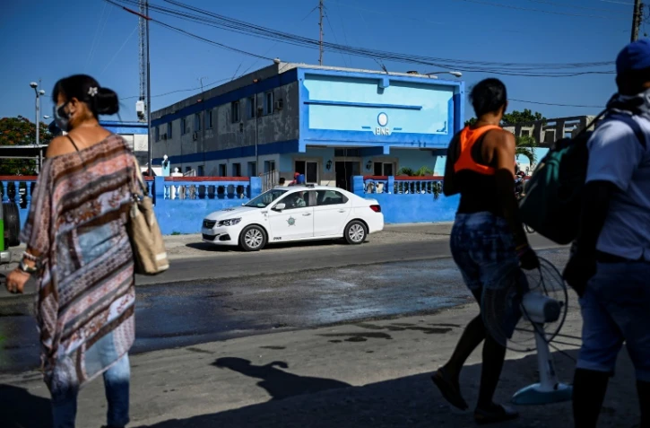 Passants près du poste de police El Capri dans la municipalité d'Arroyo Naranjo à La Havane, le 13 juillet 2021