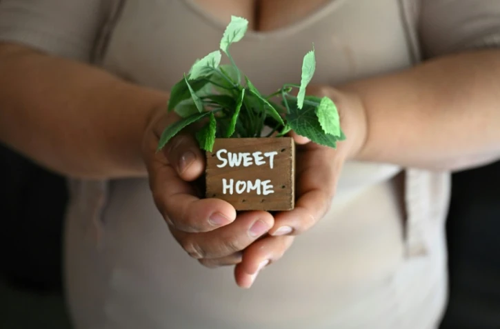 Martha, une sans-papiers mexicaine utilisant un pseudonyme, montre une décoration de son appartement avec le slogan "Doux Foyer", à Buena Park, près de Los Angeles, le 31 juillet 2025