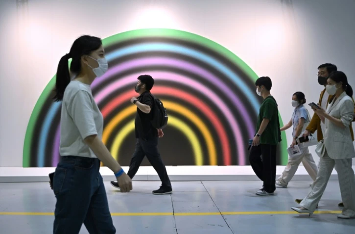 Des visiteurs devant l'oeuvre intitulée "vierzehnterseptemberzweitausendundfunfzehn, 2015" de l'artiste Ugo Rondinone exposée à la foire Frieze à Séoul, le 2 septembre 2022
