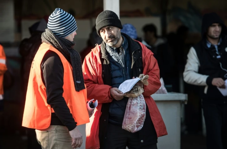 Un membre de l'OFPRA avec un de migrant le 14 janvier 2016 à Calais 