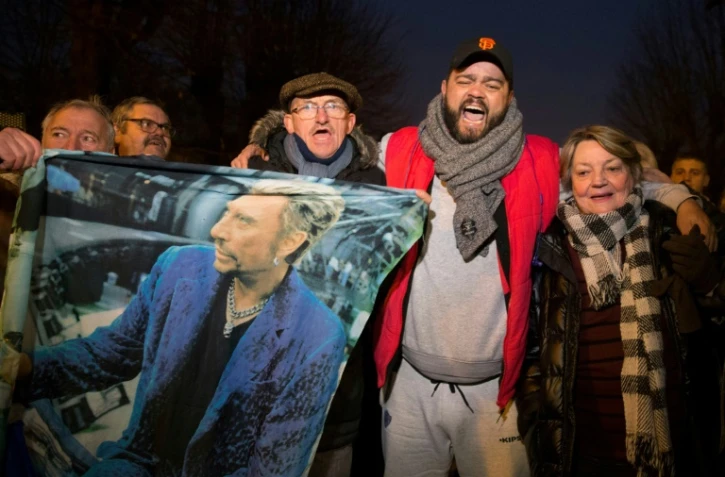 Des fans de Johnny Hallyday chantent devant sa maison de Marnes-la-Coquette, dans les Hauts-de-Seine, le 6 décembre 2017