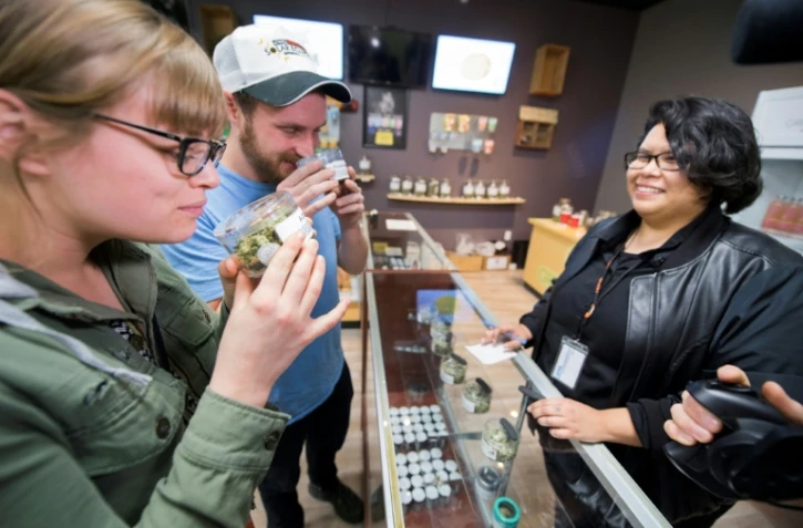 Des touristes venus de d'Arizona sentent des têtes de cannabis dans un magasin de Desert Hot Springs, en Californie, le 1er janvier 2018