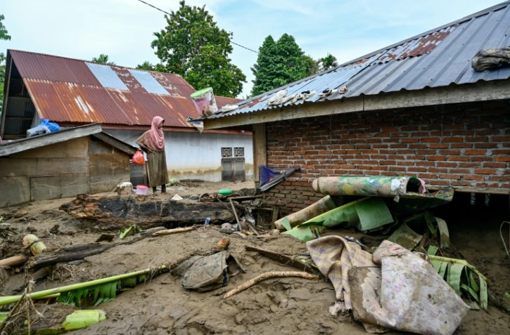 Une femme observe sa maison inondée à la suite de crues soudaines à Meureudu, dans la province d’Aceh, en Indonésie, le 28 novembre 2025