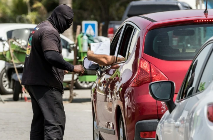 Un membre du collectif "500 frères" contrôle un véhicule alors que la route est bloquée, excepté pour les véhicules médicaux, à Cayenne, le 18 avril 2017