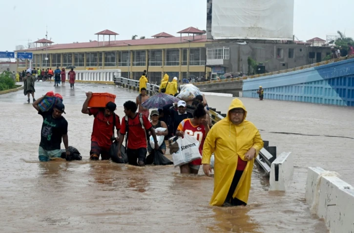 Des habitants d'Acapulco marchent dans une rue inondée après le passage de l'ouragan John à Acapulco dans l'Etat du Guerrero, dans le sud du Mexique, le 27 septembre 2024